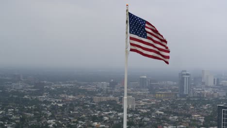 Drohnenansicht-Der-Amerikanischen-Flagge,-Die-Auf-Dem-Dach-Eines-Wolkenkratzers-In-Houston-Weht