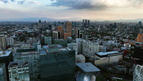 Aerial-view-backwards-over-the-Museo-Soumaya-in-Polanco,-cloudy-evening-in-Mexico-city