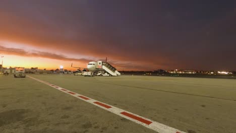 Dawn-illuminates-Malta-International-Airport,-spotlighting-aircraft-on-the-tarmac-and-terminal-lights-in-a-timelapse-still-of-early-morning-activity