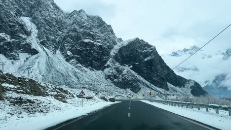 Car-driving-on-a-road-in-Skardu-in-landscape-covered-with-snow-and-high-mountains