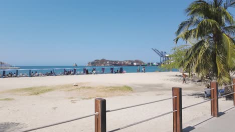 Tourists-sunbathing-on-white-sand-beach,-stretching-along-coast,-Santa-Marta-region