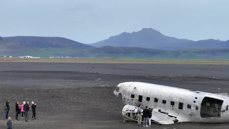 Solheimasandur,-Iceland,-Drone-Shot-of-Tourist-Visiting-Abandoned-Airplane-Wreck