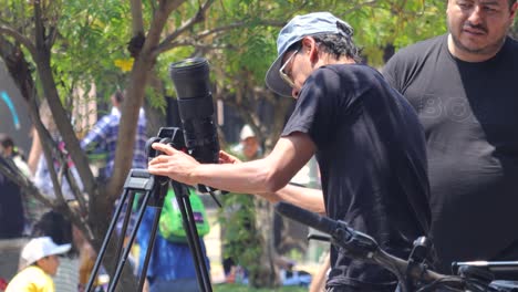 Latin-man-taking-a-photo-of-the-solar-eclipse-from-a-reflex-camera-with-a-telephoto-lens-on-a-tripod,-Mexico-April-8,-2024