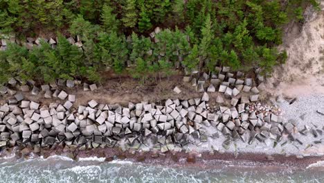 Aerial-drone-fly-close-to-stone-industrial-construction-next-to-forest-river-environmental-work-for-docks-in-countryside-landscape