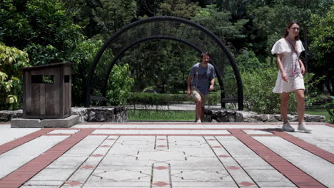 Arco-Con-Turistas-Caminando-Por-El-Jardín-Botánico-De-Perdana-En-Kuala-Lumpur,-Malasia