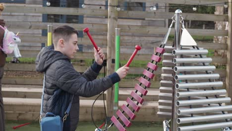 Editorial-video-footage-of-a-young-boy-playing-on-musical-attractions-in-a-public-area