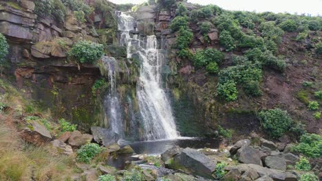 Aerial-drone-footage-of-a-tall-rocky-waterfall-in-the-Yorkshire-Dales,-Pennies