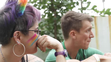 Una-Mujer-Con-Los-Colores-Del-Orgullo-Pintados-En-Su-Rostro-Conversa-Con-Sus-Amigos-Durante-El-Festival-Del-Orgullo-Midmo,-En-Columbia,-Mo.