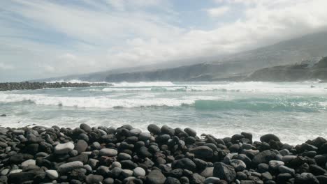 Grupo-De-Surfistas-En-Cámara-Lenta-Surfeando-Sobre-Las-Olas-Del-Océano,-Playa-De-Guijarros,-Playa-Martiánez,-Puerto-De-La-Cruz,-Islas-Canarias-En-Primavera