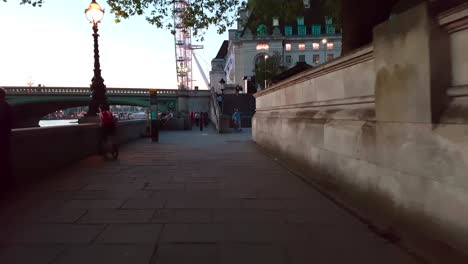 Evening-walk-next-to-the-Thames-river-with-the-London-Eye-approaching