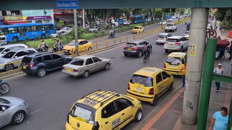 Cali,-Kolumbien,-Täglicher-Geschäftiger-Straßenverkehr,-Gelbe-Taxis-Und-Menschen