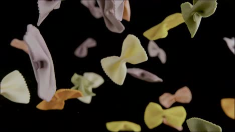 Colorful-pasta-in-the-shape-of-bows-flies-in-the-air-in-slow-motion