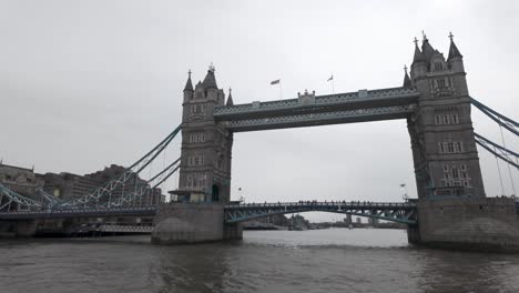 Contemplar-El-Tower-Bridge-De-Londres-Desde-Un-Crucero-Por-El-Río,-Con-El-Nublado-Cielo-Inglés-Como-Telón-De-Fondo,-Que-Resume-La-Esencia-Del-Viaje-Y-La-Exploración.