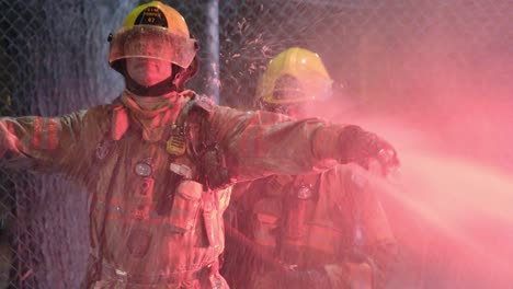 Zwei-Feuerwehrmänner-In-Voller-Montur-Beim-Abspritzen-Eines-Gebäudebrands-In-Montreal