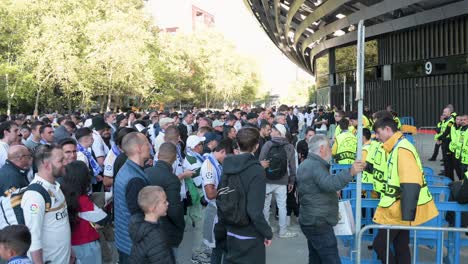 Fußballfans-Stehen-Schlange,-Um-Das-Santiago-Bernabéu-Stadion-Von-Real-Madrid-Zu-Betreten,-Während-Sie-Das-Champions-League-Fußballspiel-Zwischen-Den-Spanischen-Und-Britischen-Teams-Real-Madrid-Und-Manchester-City-Besuchen.