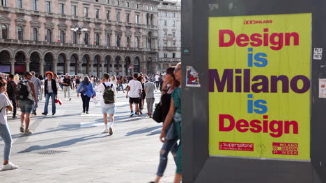 Cartelera-De-La-Semana-Del-Diseño-De-Milano-Y-Gente-Caminando-En-La-Plaza-Del-Duomo