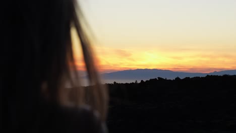 Female-admires-magical-sunrise-over-Teide-National-Park,-back-close-up-view