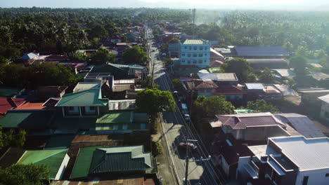 Aerial-view-following-a-road,-sunny-day-in-San-Pablo,-Laguna,-Philippines