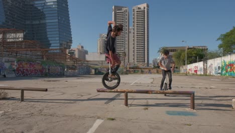 Group-of-unicyclists-balancing-on-rails-in-an-urban-space-with-skyline-buildings-in-background