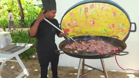 Chef-browning-Chicken-in-large-Papya-pan-at-Impressive-Resort-and-Spa-in-Punta-Cana,-Dominican-Republic