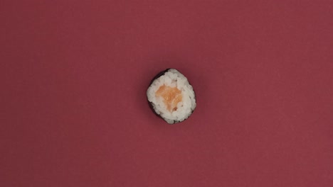 Sushi-roll-rotating-on-red-background