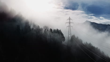 Aerial-Shot-Mystic-Atmosphere-Shadow-Forest-Tree-Bright-Light-Pylon-Blue-Sky-Mountains