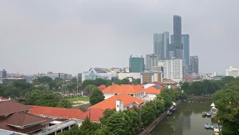 A-stunning-and-majestic-mall-in-Surabaya,-offering-views-of-a-bustling-river-adorned-with-boats-and-lush-green-spaces