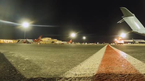 Fotograma-De-Timelapse-Antes-Del-Amanecer-Del-Aeropuerto-Internacional-De-Malta,-Que-Captura-Aviones-Alineados-Y-Luces-Brillantes-De-La-Terminal-Mientras-El-Aeropuerto-Despierta-Para-Las-Operaciones-Diarias