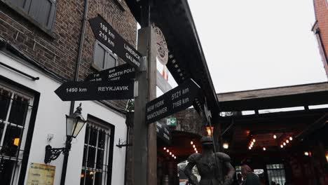 Handheld-panning-shot-of-a-directional-signpost-on-a-city-street,-Dublin