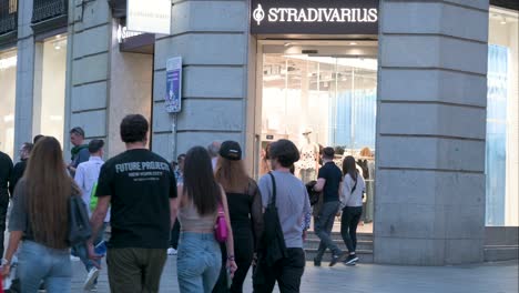 Los-Peatones-Pasan-Por-La-Marca-Española-De-Moda-Femenina-De-España-Propiedad-Del-Grupo-Inditex,-Stradivarius,-Tienda-Durante-La-Noche