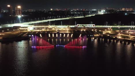 Establishing-Shots-Drone-camera-moving-downwards-to-a-large-colorful-fountain-moving-forward-and-people-watching