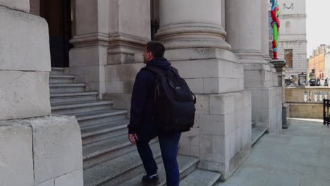 Young-man-ascends-the-stairs-to-Dublin's-City-Hall-main-entrance