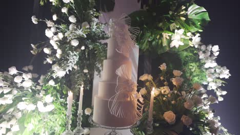 Pastel-De-Bodas-Blanco-Diseñado-Con-Varios-Niveles-Y-Decorado-Con-Cintas-Y-Flores.