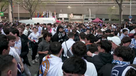 Fußballfans-Moshen-Gemeinsam-Vor-Dem-Santiago-Bernabéu-Stadion-Von-Real-Madrid,-Als-Sie-Sich-Versammeln,-Um-Das-Champions-League-Fußballspiel-Zwischen-Den-Mannschaften-Real-Madrid-Und-Manchester-City-Zu-Besuchen