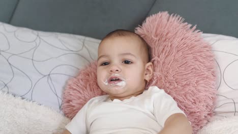 Close-up-portrait-of-a-little-girl,-an-infant,-being-fed-by-her-mother's-hands-with-porridge-from-a-spoon