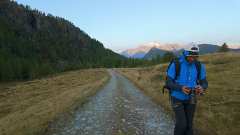 Fotógrafo-De-Naturaleza-Con-Cámara-Caminando-Por-Un-Sendero-Panorámico-A-Través-De-Los-Alpes-Italianos.