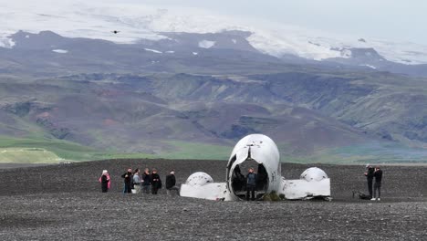 Drones-Volando-Por-Encima-Y-Alrededor-De-Aviones-Abandonados-Y-Turistas-En-La-Costa-De-Islandia