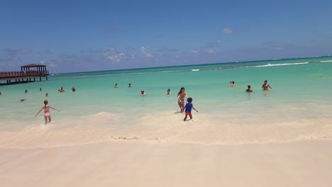 Women-and-small-boy-swimming-on-Blue-Beach-at-Impressive-Resort-and-Spa-in-Punta-Cana,-Domincan-Republic