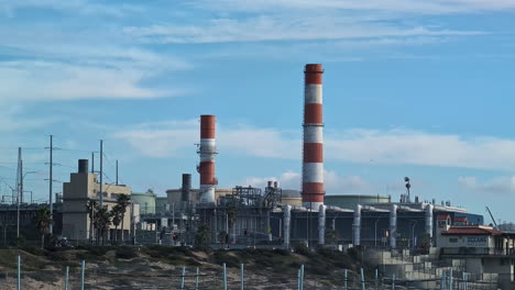 Tall-chimneys-of-factory-in-Los-Angeles,-California,-handheld-view