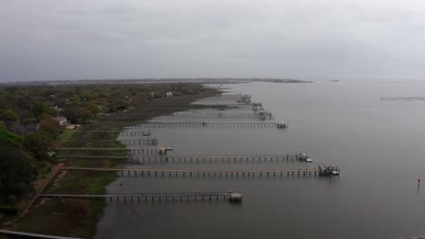 Amplia-Toma-Aérea-Volando-Sobre-Largos-Muelles-De-Pesca-A-Lo-Largo-Del-Puerto-De-Charleston-En-Un-Día-Brumoso-En-El-Antiguo-Pueblo-De-Mount-Pleasant,-Carolina-Del-Sur