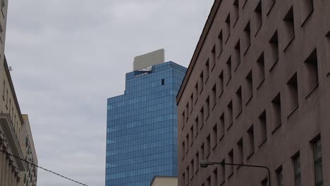 Observing-the-Office-Moniuszki-Tower-in-Warsaw,-Poland,-set-against-a-backdrop-of-cloudy-skies,-embodies-the-concept-of-urban-dynamism-and-architectural-majesty