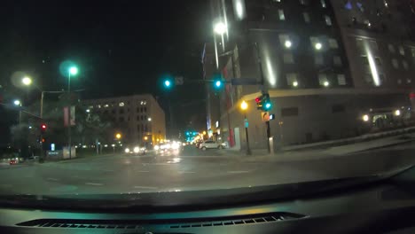 Series-number-four-hyperlapse-showing-car-driving-through-downtown-Dallas-Texas-at-night-with-city-lights,-stop-lights,-brightly-lit-up-towers,-and-city-intersections