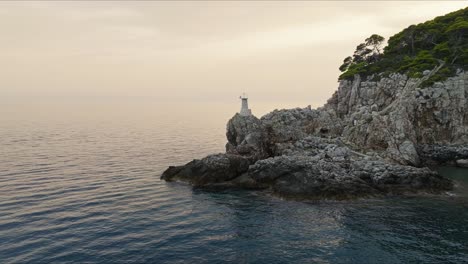 Isla-De-Kalamota,-Mar-Adriático,-Croacia---La-Vista-De-Un-Faro-Situado-En-Un-Acantilado-Escarpado---Toma-Aérea-De-Retroceso