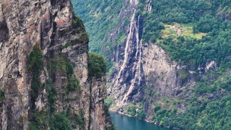 Vista-Aérea-De-La-Pintoresca-Cascada-Y-Empinadas-Colinas-Sobre-El-Fiordo-De-Geiranger,-Noruega