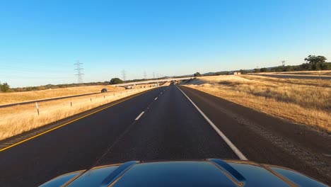 Car-drives-on-I10-in-Texas-Hill-Country-near-Kerrville,-Texas,-USA,-POV-wide-shot