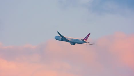 Commercial-airplane-ascending-against-a-dusk-sky,-clear-weather