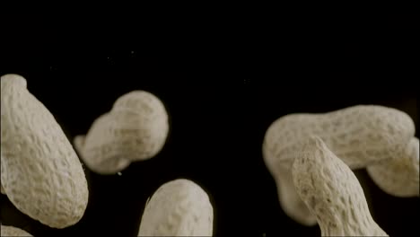 High-quality-slow-motion-footage-of-flying-peanuts-set-against-a-striking-black-backdrop