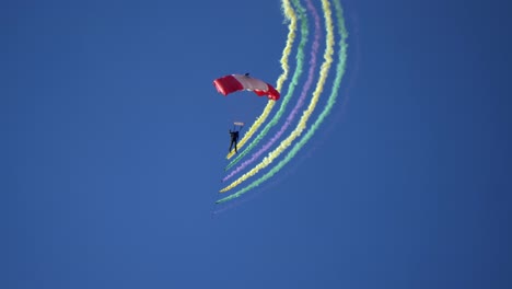 A-SkyHawks-Skydiver-Spiraling-Down-Trailing-Colorful-Smoke---Low-Angle