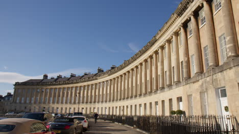 Man-Walking-In-Front-Of-The-Circus-Townhouses-In-Bath,-Somerset,-England,-UK