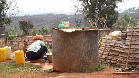 A-woman-is-washing-the-dishes-in-the-backyard,-in-Myanmar